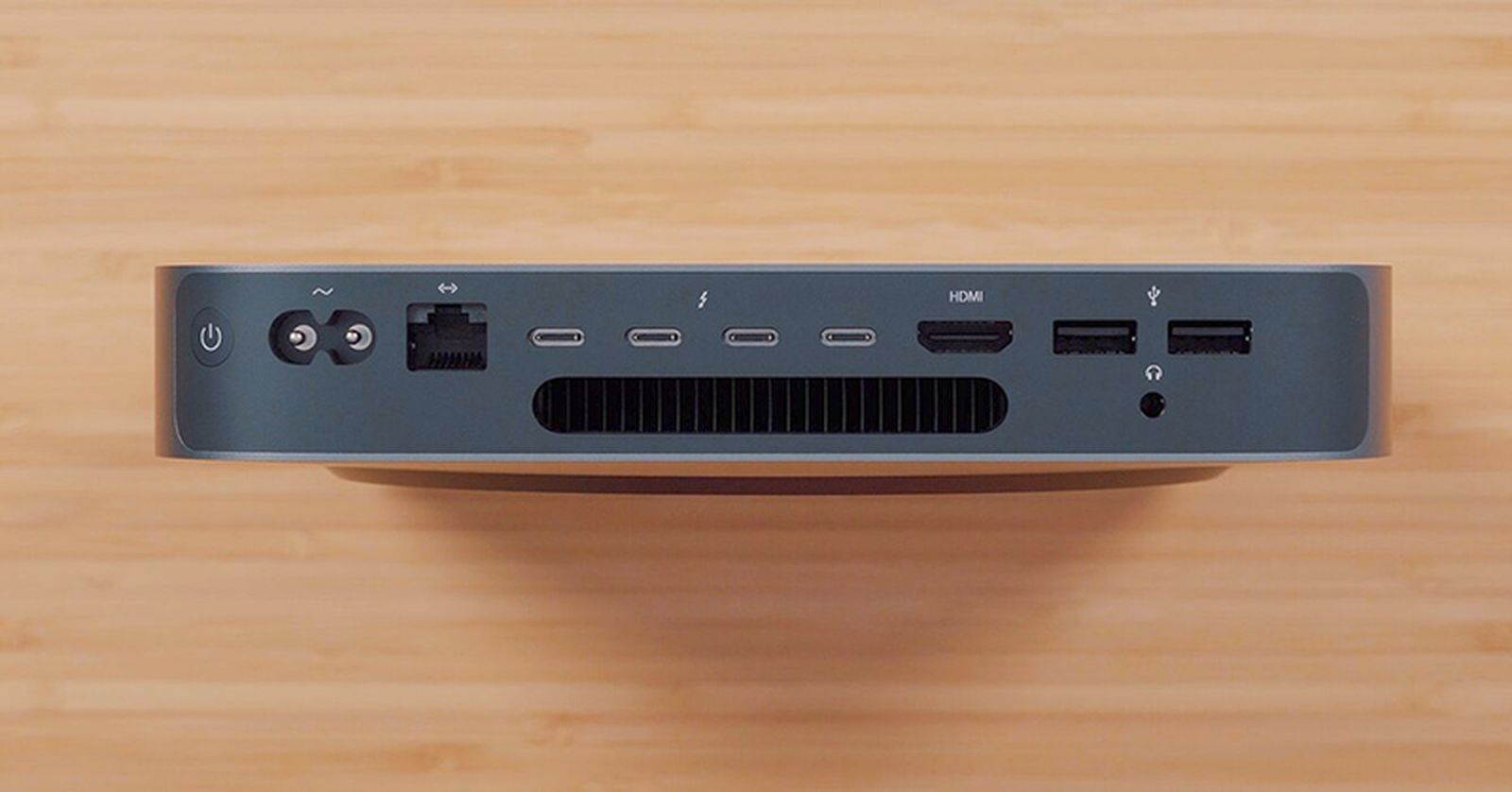 Back of a space-gray 2018 Mac mini showing power, Ethernet, four USB-C ports, HDMI, two USB-A ports and a headphone jack